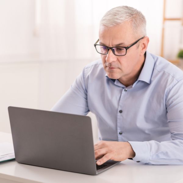 A middle-aged man on his laptop at home